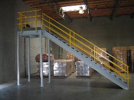 Metal stairs with yellow railing, in a warehouse